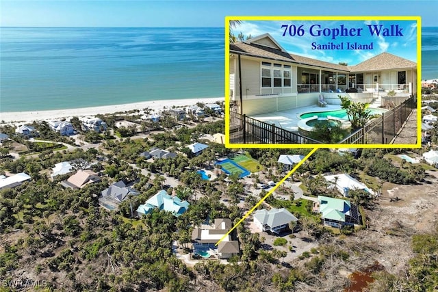 birds eye view of property with a water view and a beach view