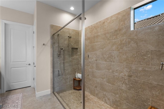 bathroom featuring tiled shower and tile patterned flooring