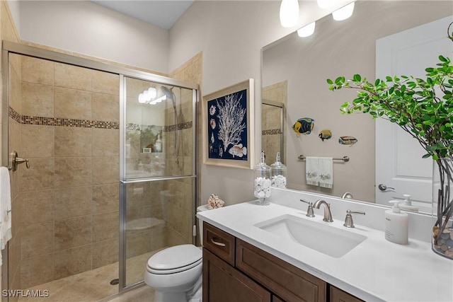 bathroom with vanity, toilet, and a shower with shower door