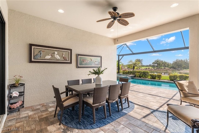 view of patio featuring a swimming pool with hot tub, ceiling fan, and glass enclosure