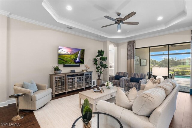 living room featuring a raised ceiling, crown molding, hardwood / wood-style floors, and ceiling fan