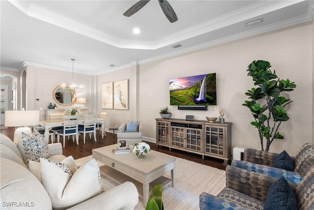 living room featuring dark hardwood / wood-style flooring, crown molding, ceiling fan with notable chandelier, and a raised ceiling