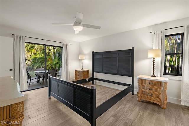 bedroom featuring light hardwood / wood-style floors, multiple windows, and access to outside