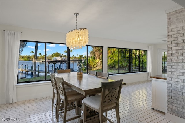 dining room with a water view, a chandelier, and a wealth of natural light