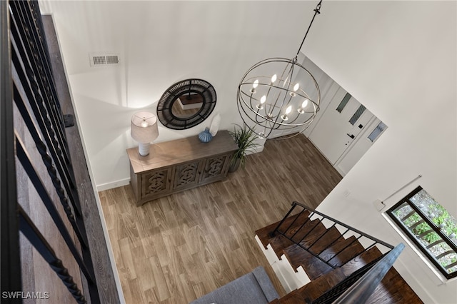 stairway featuring hardwood / wood-style floors and a chandelier