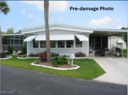 view of front of property with a carport and a front yard