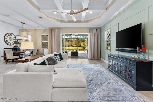 living room featuring ceiling fan with notable chandelier, coffered ceiling, light hardwood / wood-style floors, crown molding, and beam ceiling