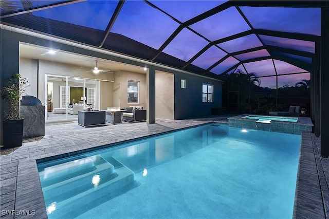 pool at dusk with a lanai, ceiling fan, a patio, an outdoor living space, and an in ground hot tub