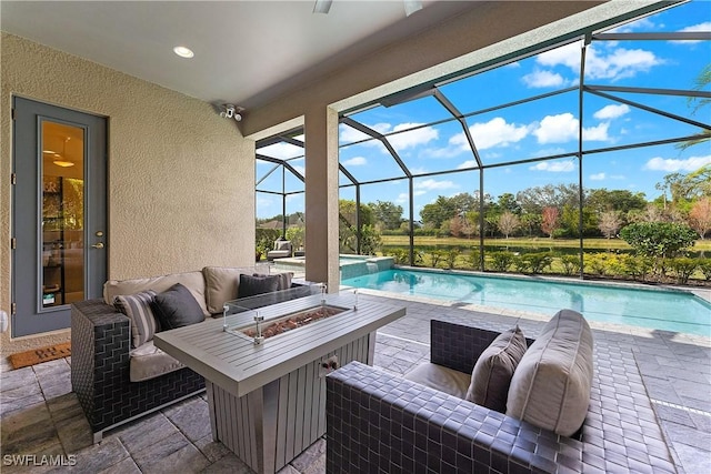 view of pool with an outdoor living space with a fire pit and a patio area