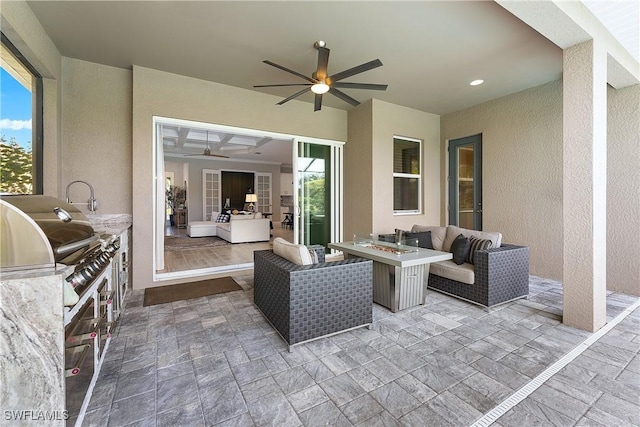 view of patio with grilling area, an outdoor living space with a fire pit, ceiling fan, and exterior kitchen