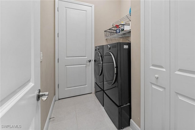 laundry room featuring light tile patterned flooring and washer and clothes dryer