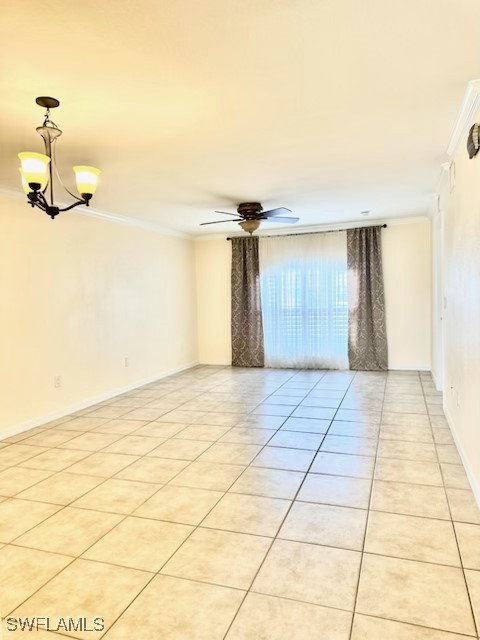 tiled spare room with crown molding and ceiling fan with notable chandelier