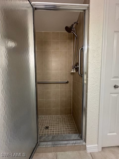 bathroom featuring a shower with door and tile patterned flooring