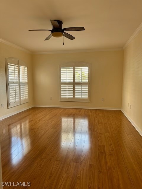 empty room featuring hardwood / wood-style flooring, ceiling fan, plenty of natural light, and crown molding