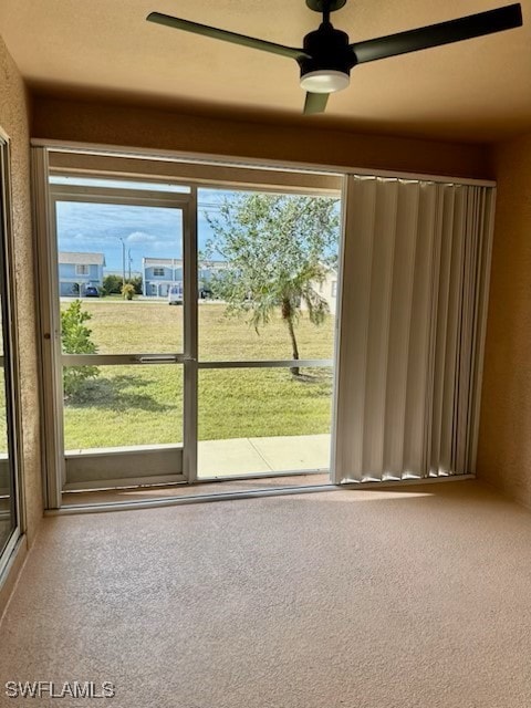 doorway to outside featuring carpet and ceiling fan