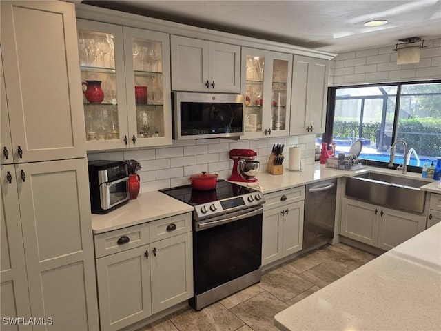 kitchen featuring stainless steel appliances, sink, and decorative backsplash