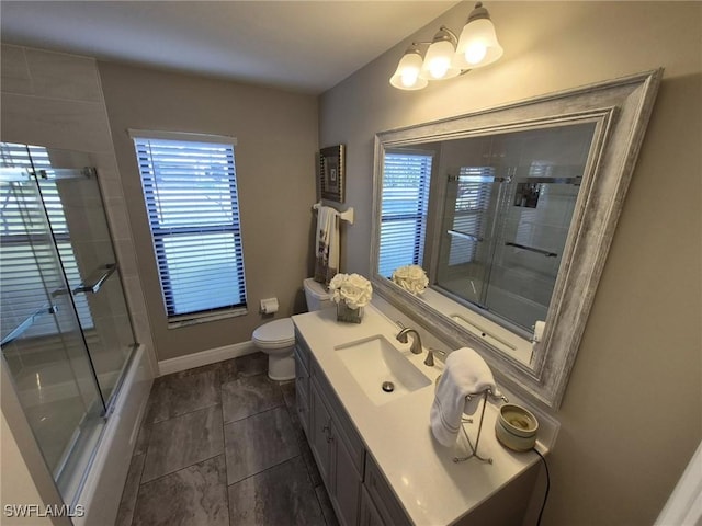 full bathroom featuring vanity, combined bath / shower with glass door, and plenty of natural light