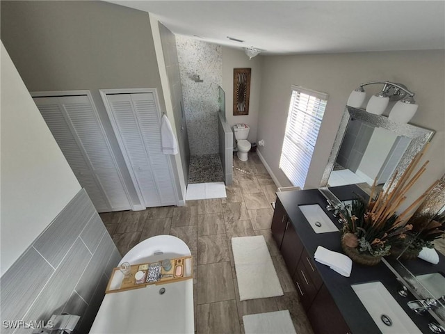 bathroom with walk in shower, vanity, and toilet