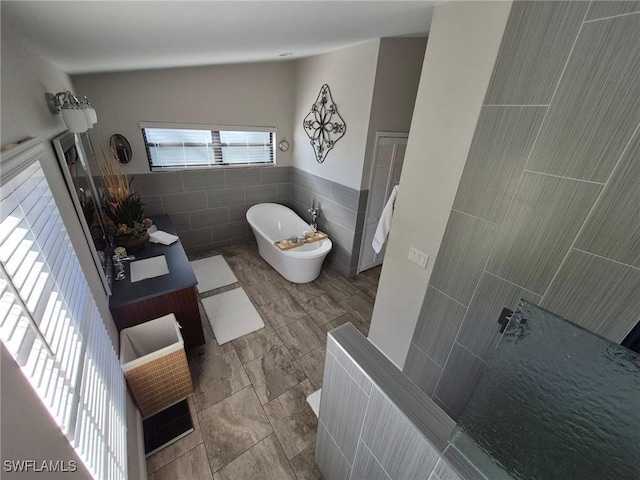 bathroom featuring vanity, tile walls, and a tub