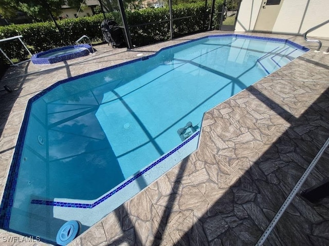 view of pool with an in ground hot tub and glass enclosure