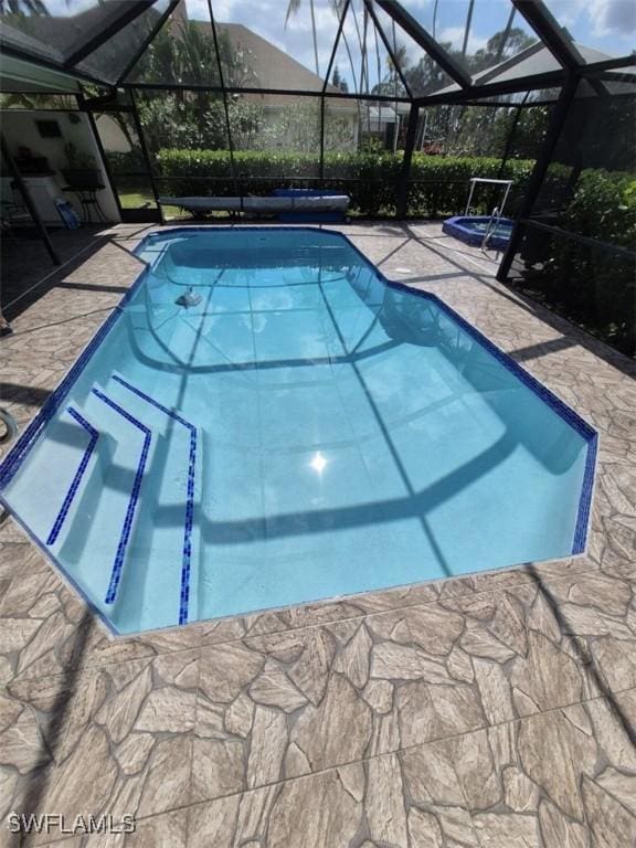 view of pool featuring a patio area and glass enclosure