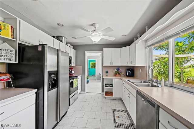 kitchen featuring stainless steel appliances, sink, white cabinets, and ceiling fan