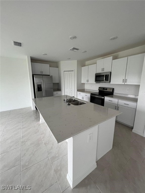 kitchen featuring appliances with stainless steel finishes, sink, a center island with sink, and white cabinets