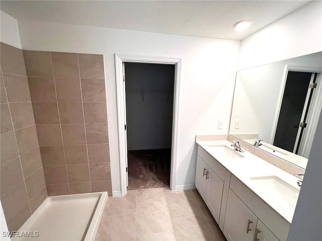 bathroom featuring vanity, tile patterned flooring, and tiled shower