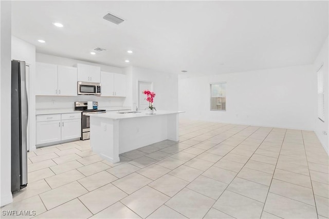 12230 Dakota Ridge Pl, Lehigh Acres, FL 33974 - kitchen with stainless steel appliances, open floor plan, light countertops, recessed lighting, and white cabinetry