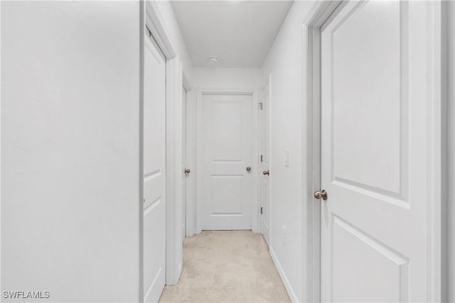 12230 Dakota Ridge Pl, Lehigh Acres, FL 33974 - hallway featuring light carpet and baseboards