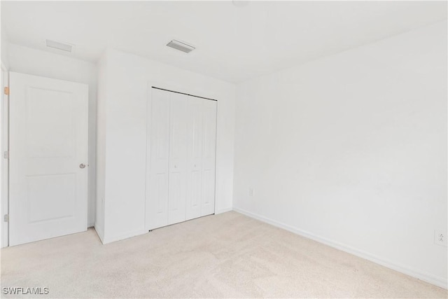 12230 Dakota Ridge Pl, Lehigh Acres, FL 33974 - unfurnished bedroom with light colored carpet, baseboards, and a closet