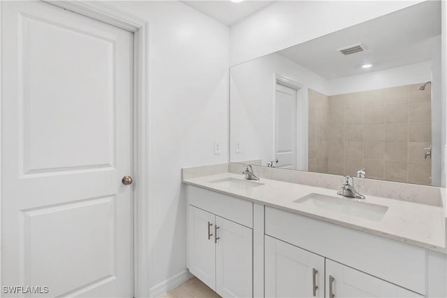 12230 Dakota Ridge Pl, Lehigh Acres, FL 33974 - bathroom featuring double vanity, tiled shower, tile patterned floors, and baseboards