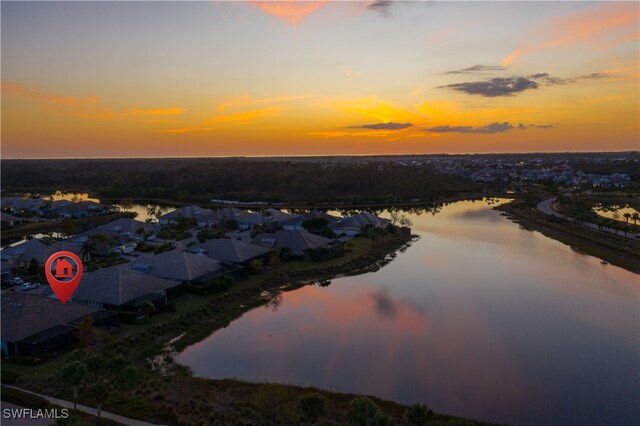 aerial view at dusk featuring a water view