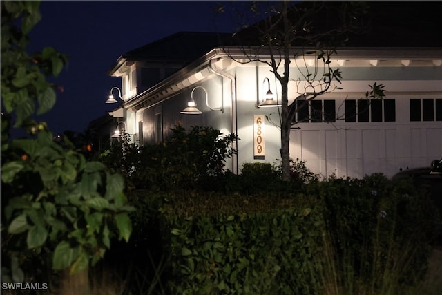 property exterior at night featuring a garage