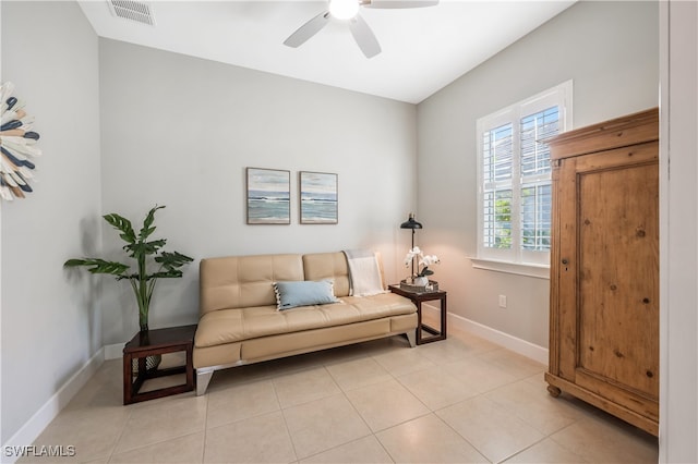 living area with light tile patterned floors and ceiling fan