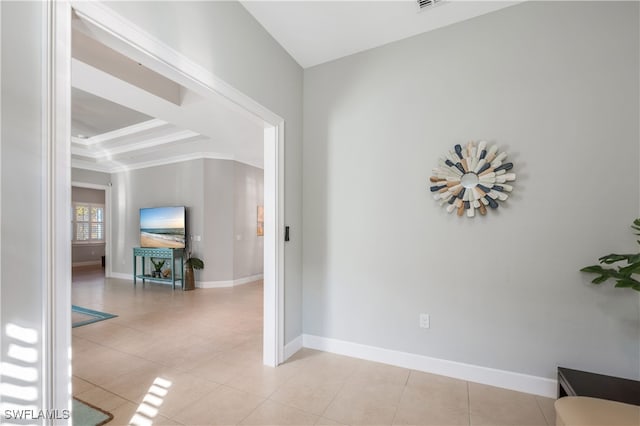 corridor featuring light tile patterned floors, visible vents, baseboards, and ornamental molding