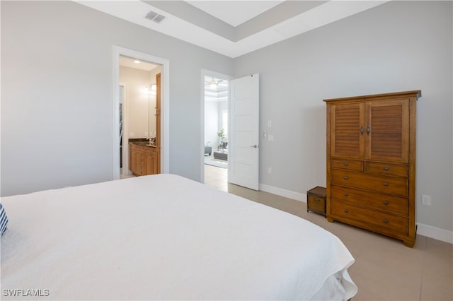 bedroom with light tile patterned flooring, connected bathroom, visible vents, and baseboards