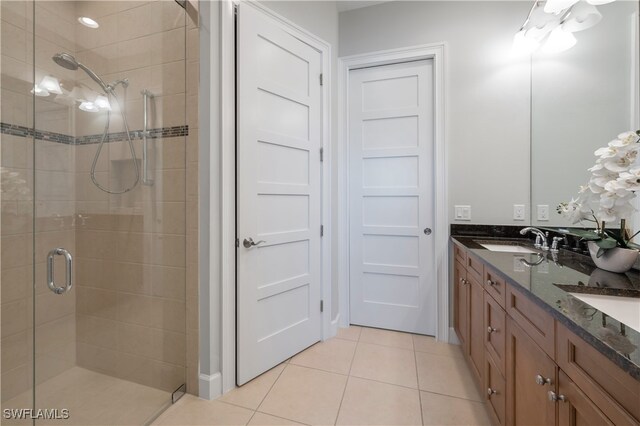 bathroom with tile patterned floors, a shower with shower door, and vanity