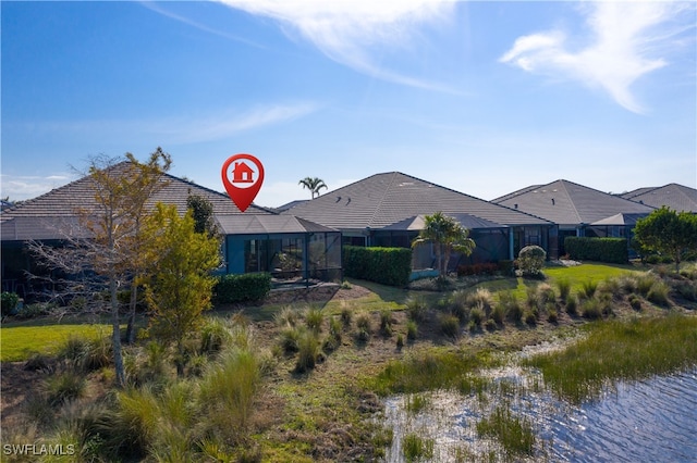 rear view of house featuring a water view and glass enclosure