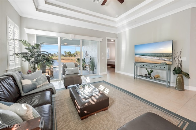 living room featuring crown molding, tile patterned floors, ceiling fan, and a tray ceiling