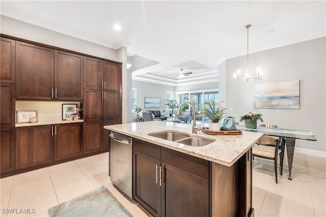 kitchen featuring pendant lighting, sink, stainless steel dishwasher, light stone counters, and a center island with sink