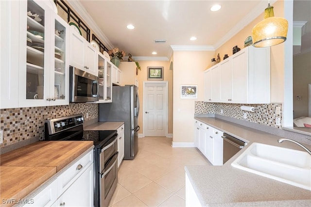 kitchen with white cabinetry, appliances with stainless steel finishes, decorative light fixtures, and sink