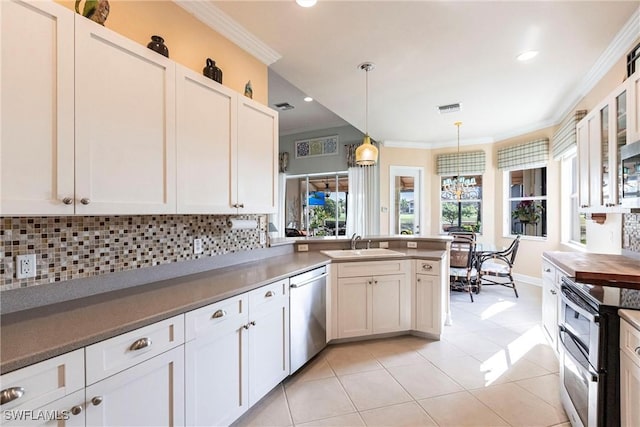 kitchen featuring appliances with stainless steel finishes, pendant lighting, sink, white cabinets, and crown molding