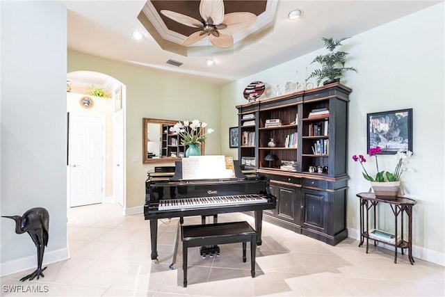 misc room featuring ceiling fan, ornamental molding, a raised ceiling, and light tile patterned floors