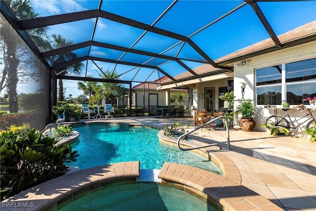 view of pool featuring an in ground hot tub, glass enclosure, and a patio area