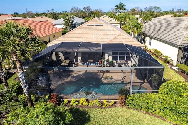 rear view of property with a lanai and a patio area