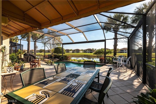 view of patio / terrace featuring a lanai and a water view