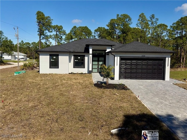 view of front of home featuring a garage and a front lawn