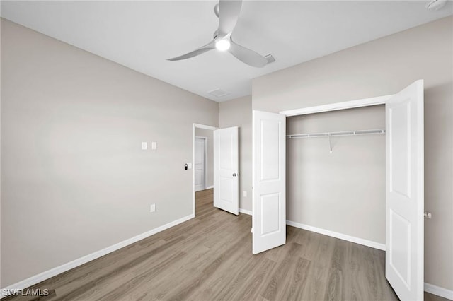 unfurnished bedroom featuring hardwood / wood-style flooring, a closet, and ceiling fan