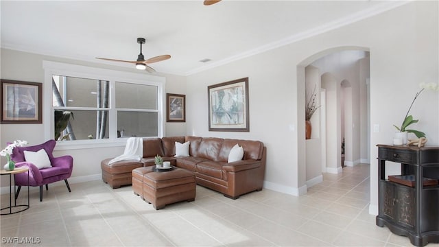 living area featuring baseboards, arched walkways, ceiling fan, and ornamental molding